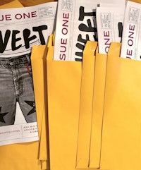 a stack of yellow envelopes with a magazine inside